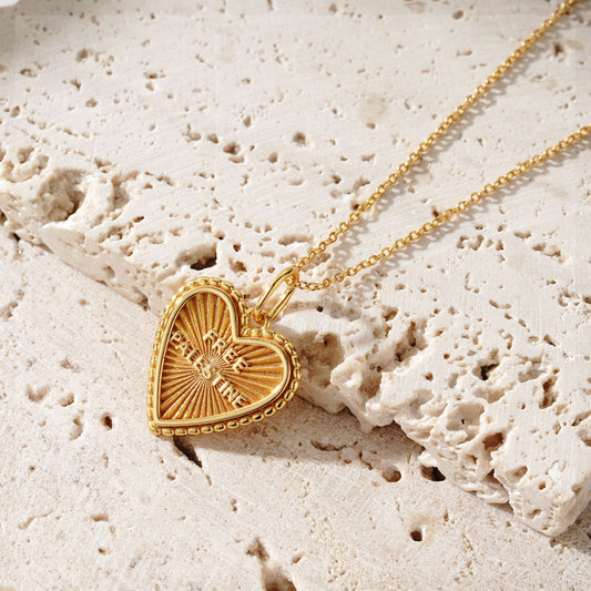 Image shows a gold pendant necklace. The pendant is a heart shape with the text 'Free Palestine'.