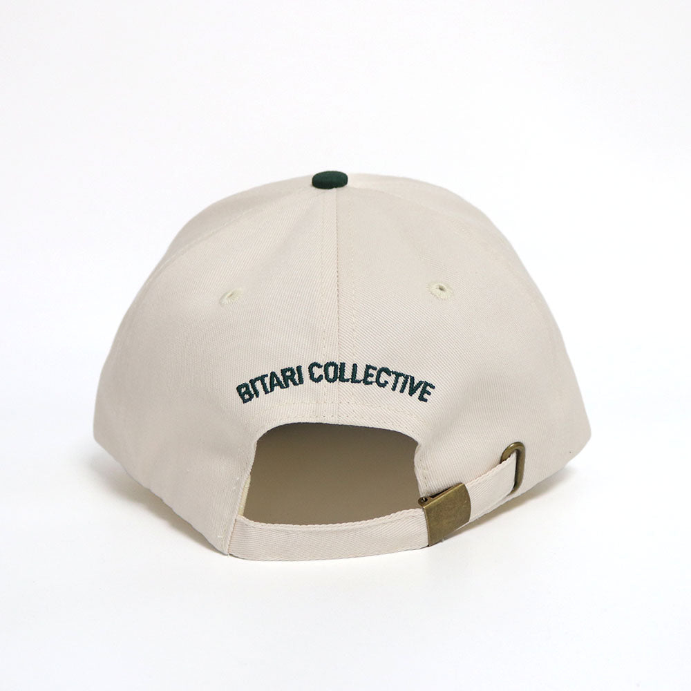 Back of an off-white and green dad hat with with the text 'Bitari Collective' embroidered in Green.