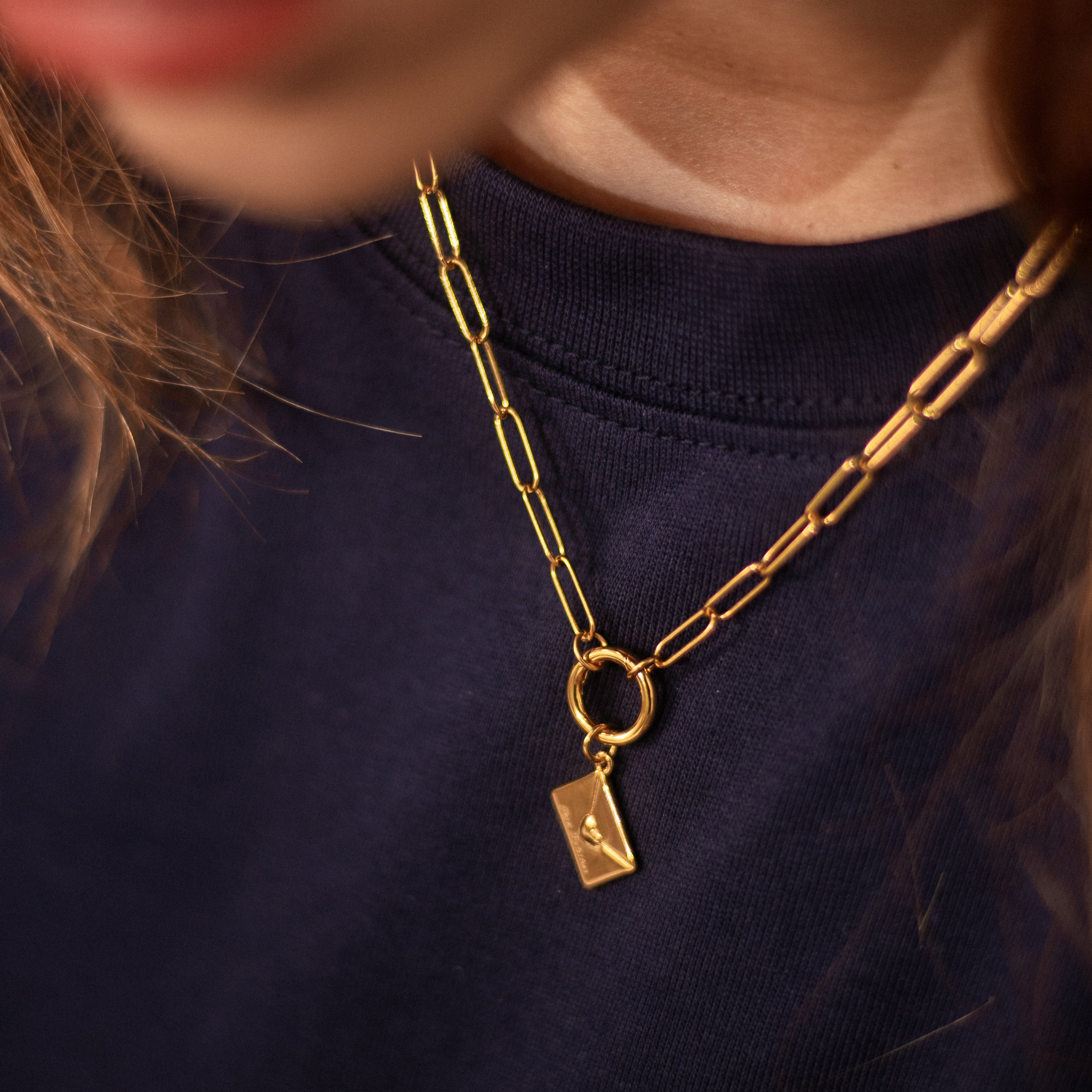 One envelope with 'Free Palestine' text on a gold paperclip chain necklace.