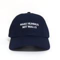 Blue dad hat with with the text 'make hummus not walls' embroidered in white.