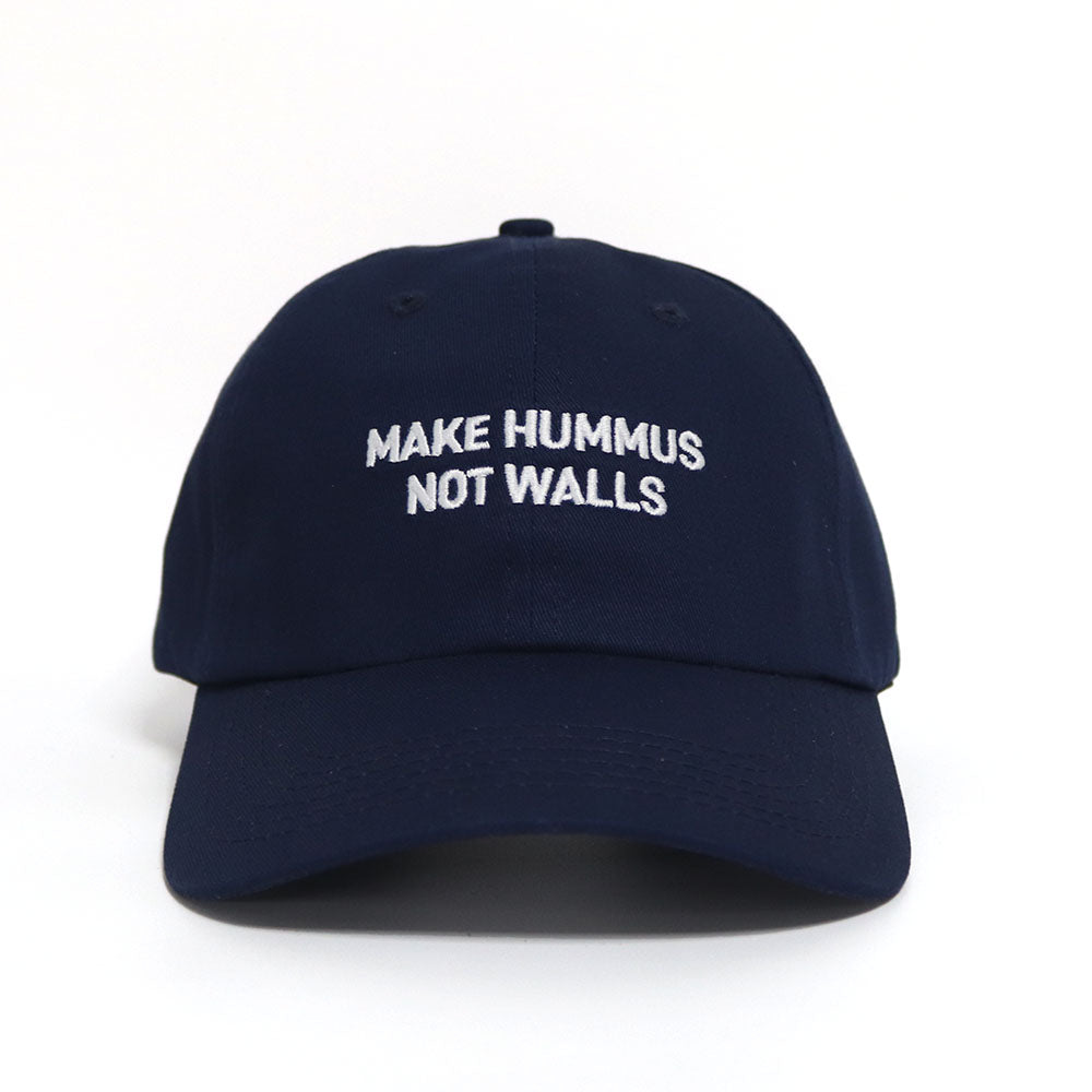Blue dad hat with with the text 'make hummus not walls' embroidered in white.