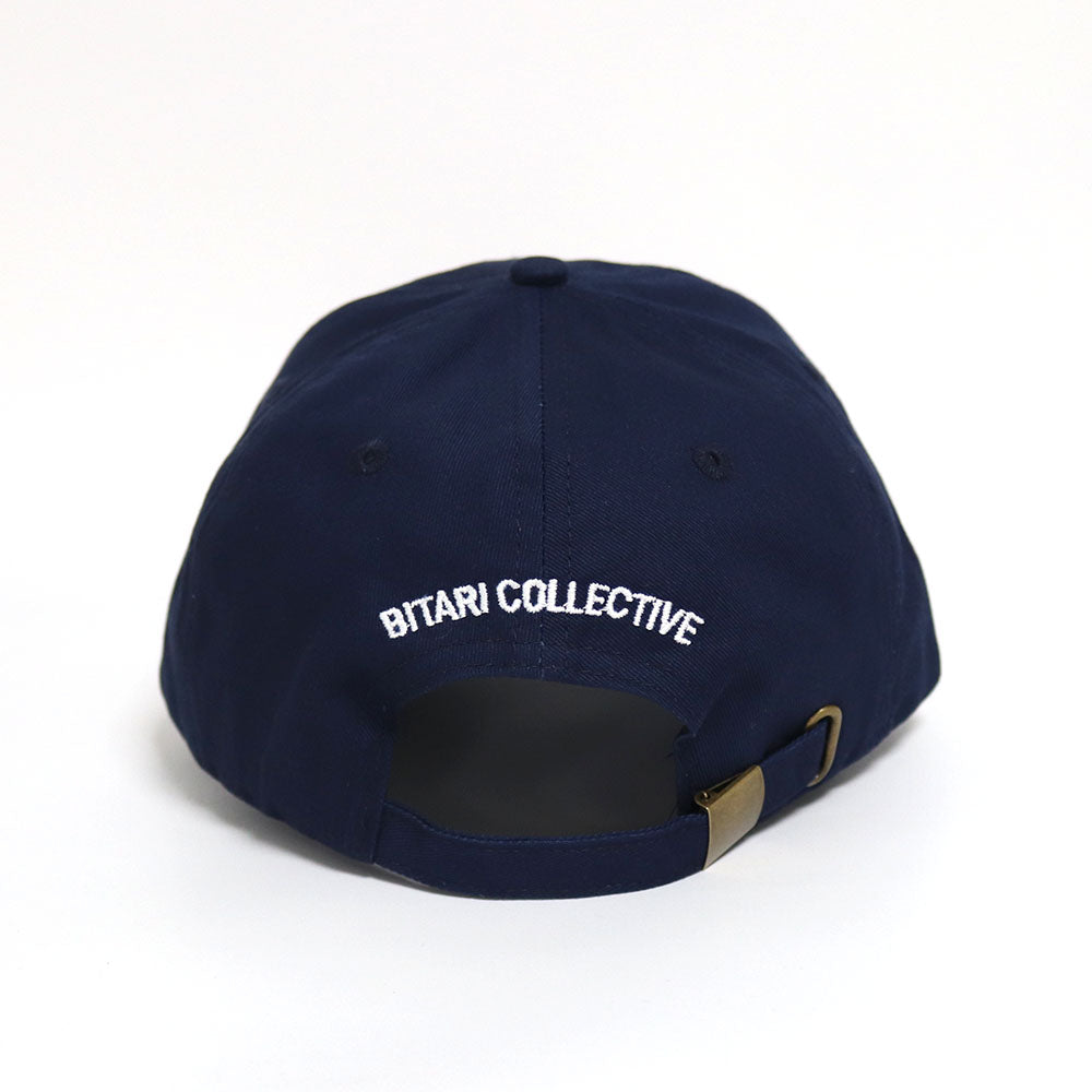 The back of a blue dad hat with with the text 'Bitari Collective' embroidered in white.